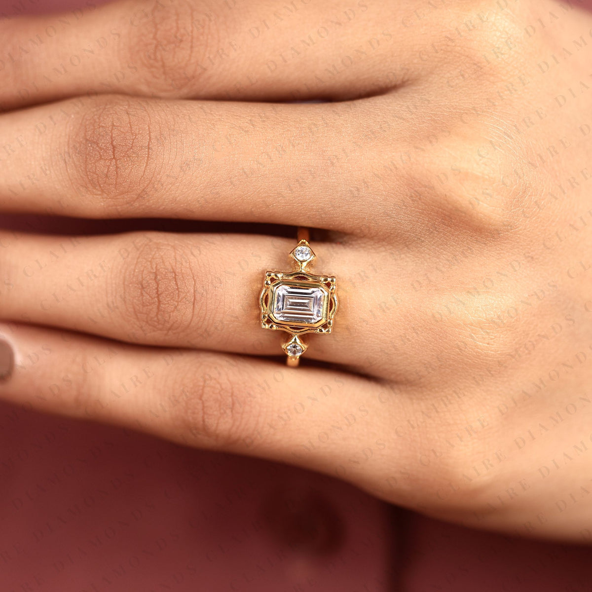 emerald cut three stone bezel set moissanite diamond engagement ring | yellow gold bezel ring with round side diamonds | sculpted luxury bridal ring