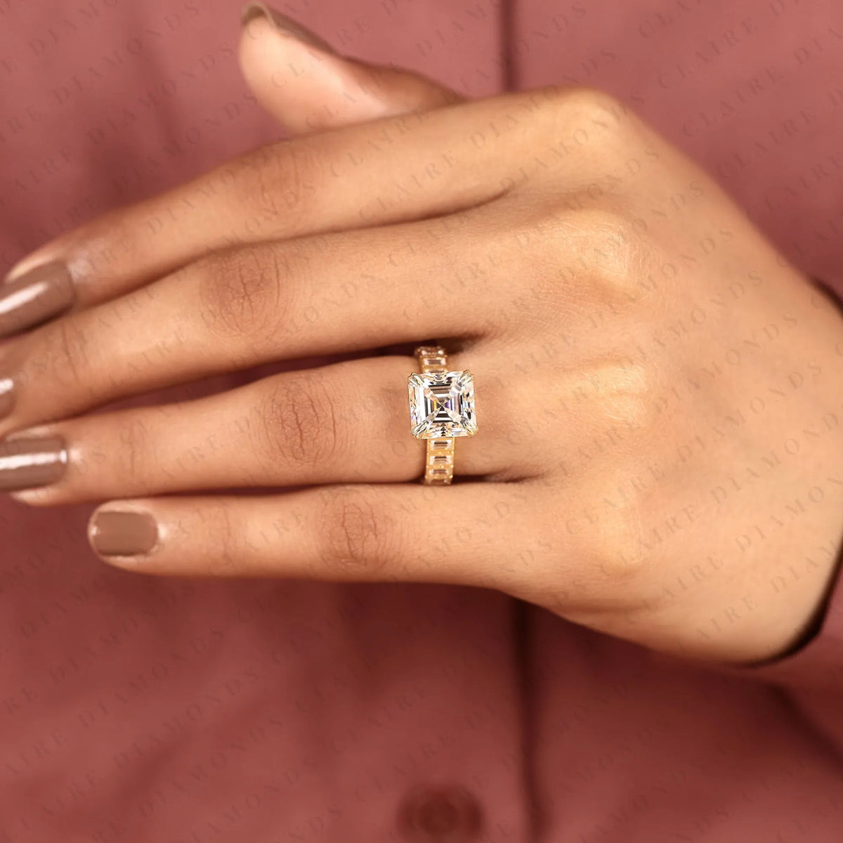 asscher cut moissanite engagement ring with baguette accent band in gold.