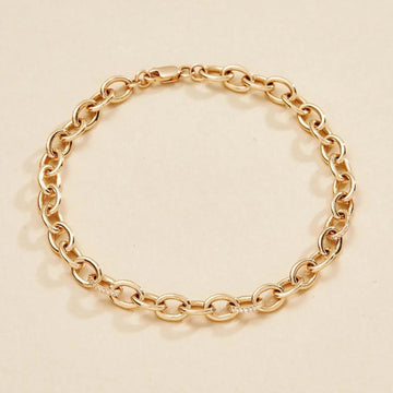 Gold chain bracelet on a beige