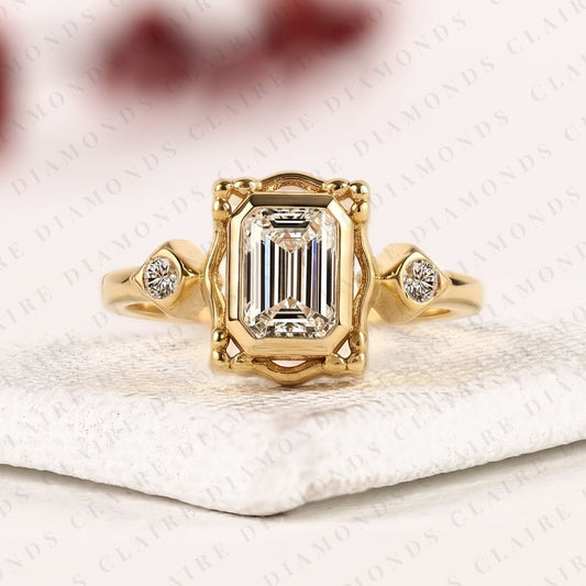 Emerald Cut Three Stone Bezel Set Lab Grown Diamond Engagement Ring | Yellow Gold Bezel Ring with Round Side Diamonds | Sculpted Luxury Bridal Ring