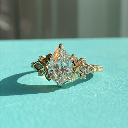 Vintage Inspired Pear Cut Moissanite Diamond Engagement Ring with Floral Leaf Side Accents in Solid Gold