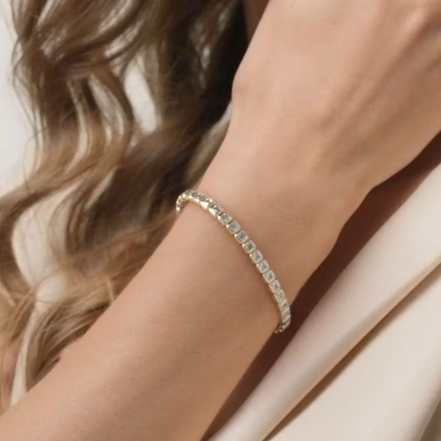 gold bracelet on a wrist with a neutral 