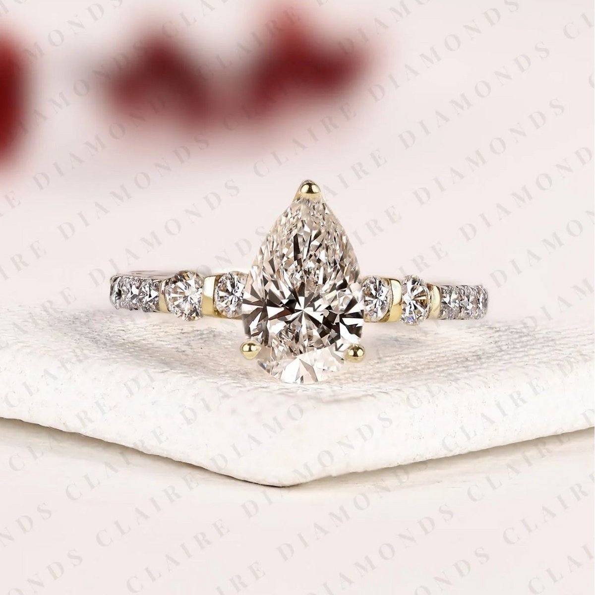 pear cut moissanite diamond engagement ring in two tone gold shoulder ring with round diamond accents