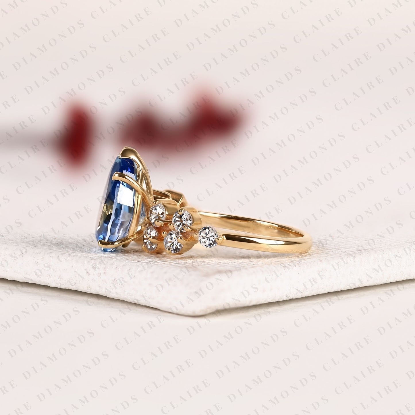 pear cut blue lab grown engagement ring, round diamond floral side stones, yellow gold nature-inspired bridal ring