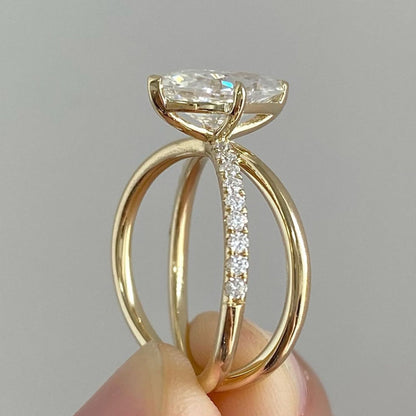 Gold ring with a diamond held in hand against a gray 