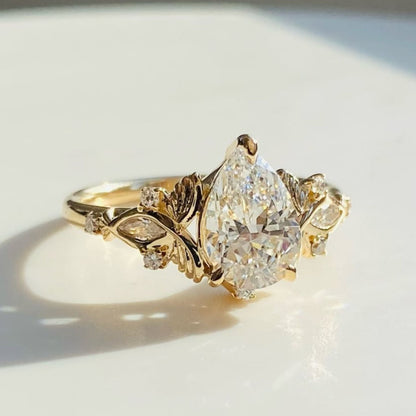 Vintage Inspired Pear Cut Moissanite Diamond Engagement Ring with Floral Leaf Side Accents in Solid Gold