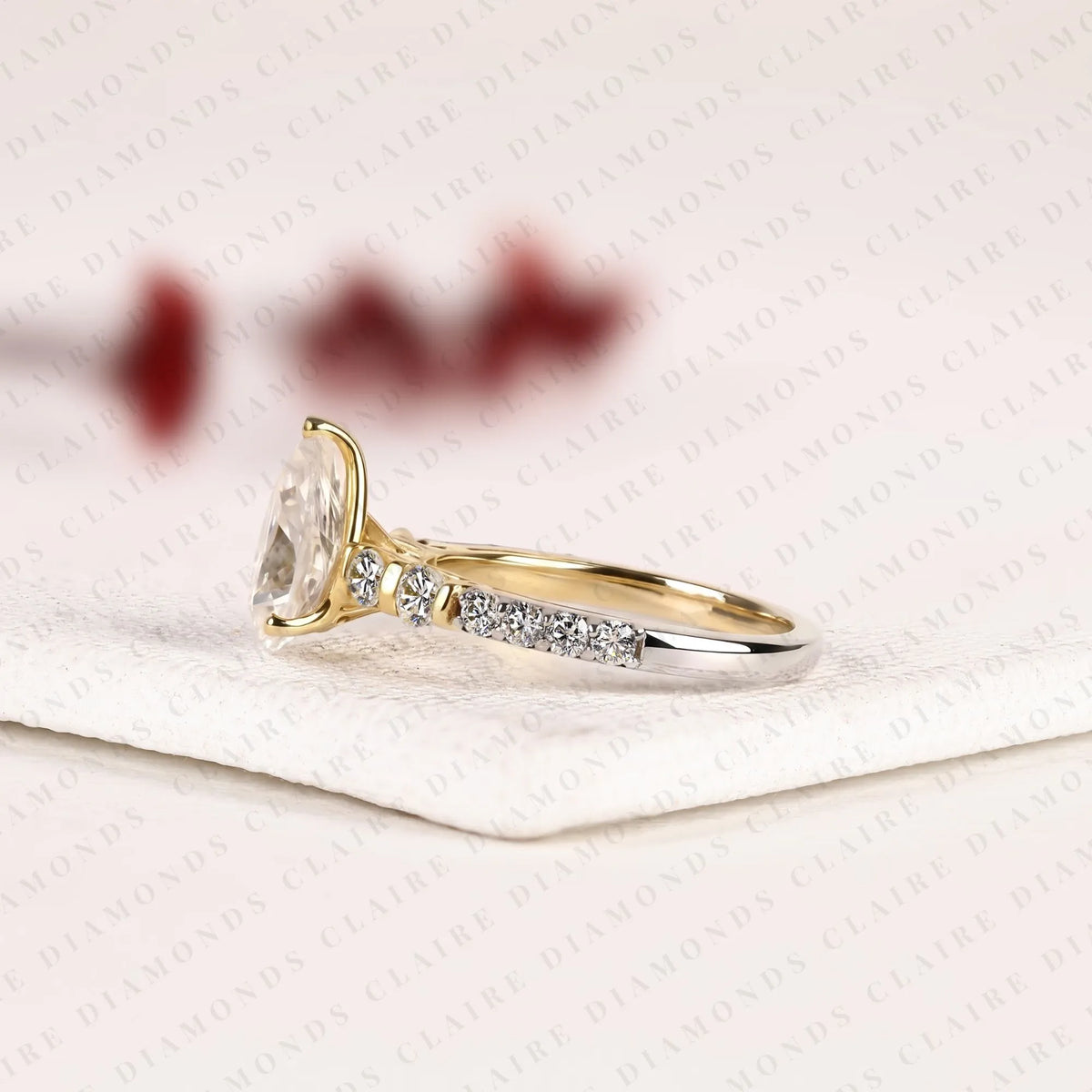 pear cut moissanite diamond engagement ring in two tone gold shoulder ring with round diamond accents