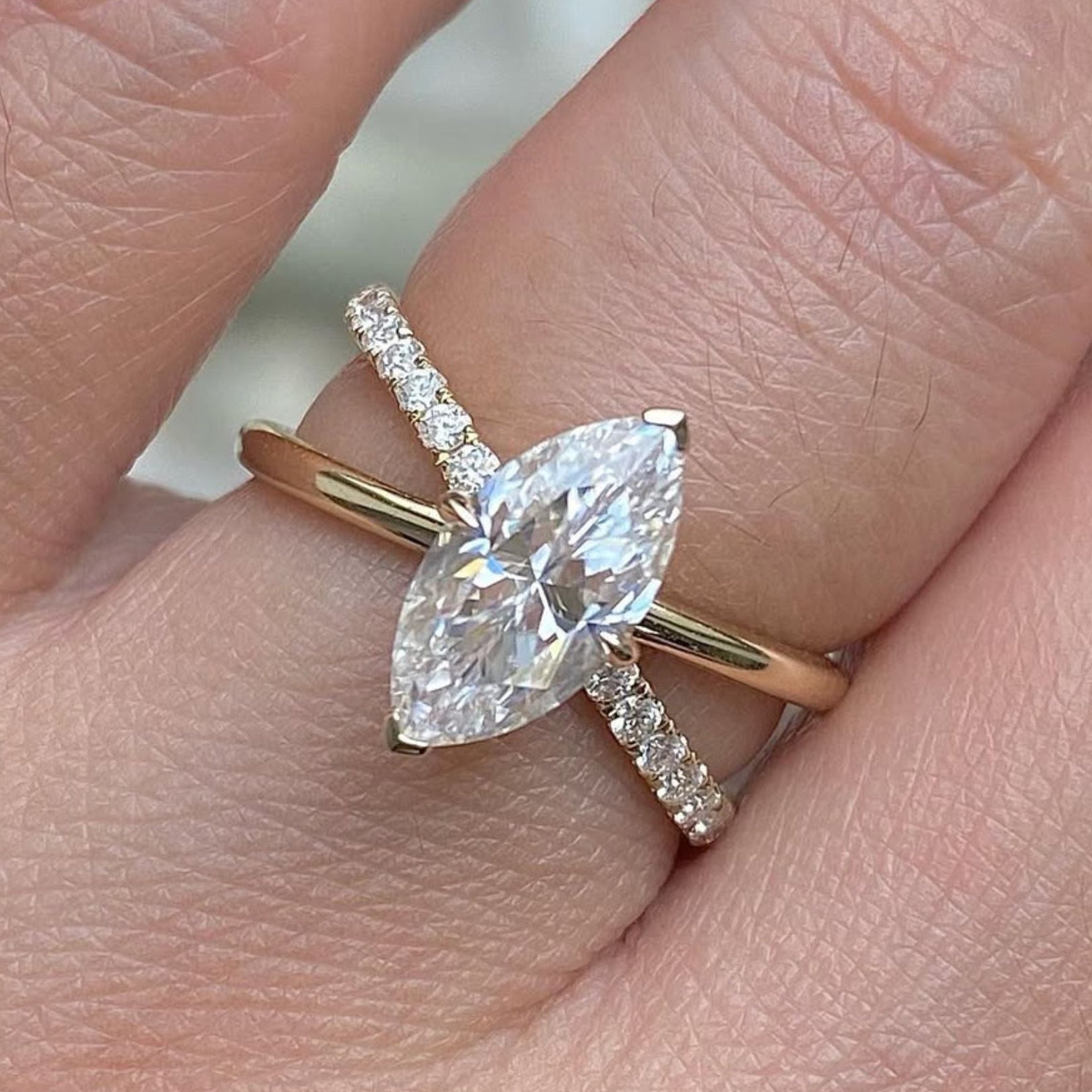 Rose gold ring with a pear-shaped diamond on a finger