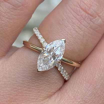 Rose gold ring with a pear-shaped diamond on a finger