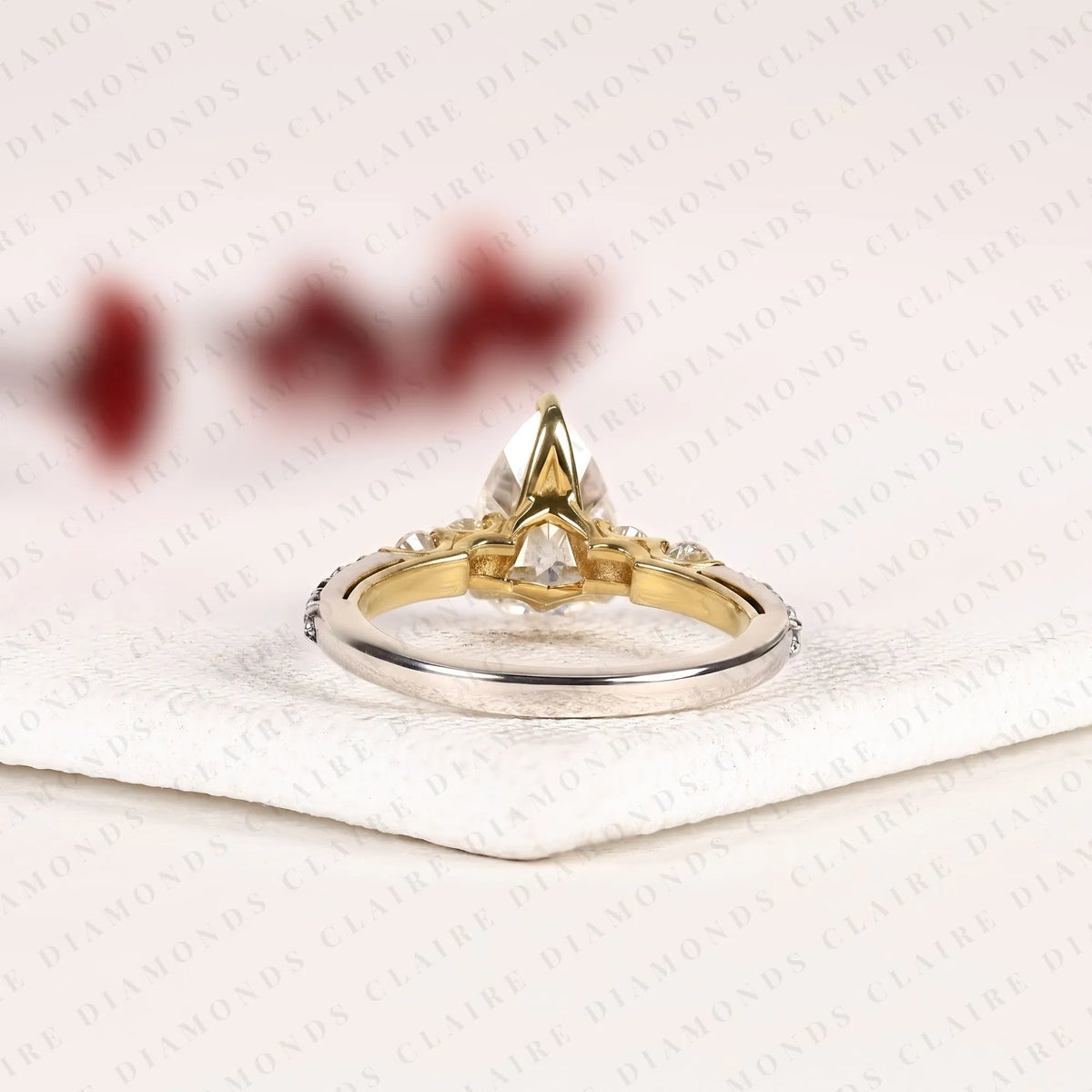 pear cut moissanite diamond engagement ring in two tone gold shoulder ring with round diamond accents