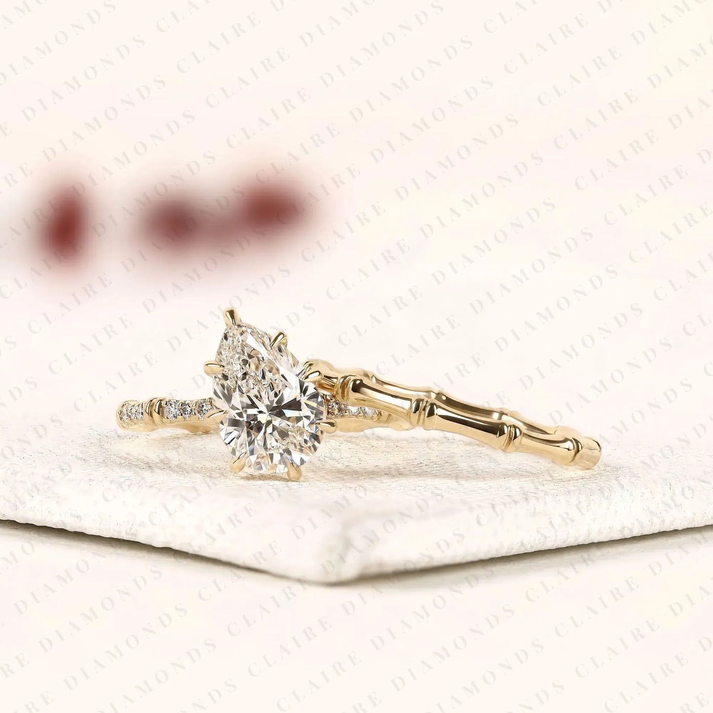 luxury pear cut lab grown diamond engagement ring with pavé diamond accents and bamboo inspired matching wedding band set