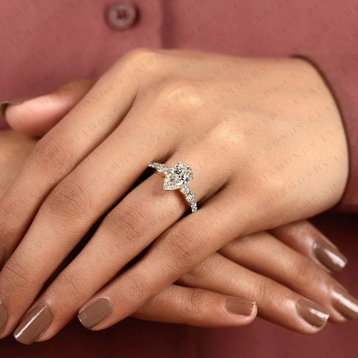 pear cut moissanite diamond engagement ring in two tone gold shoulder ring with round diamond accents
