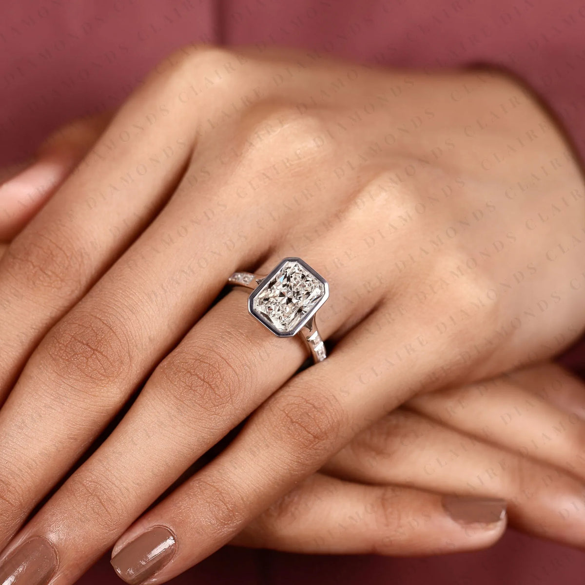 radiant cut moissanite diamond bezel set engagement ring with baguette pave set white gold modern luxury bridal jewelry