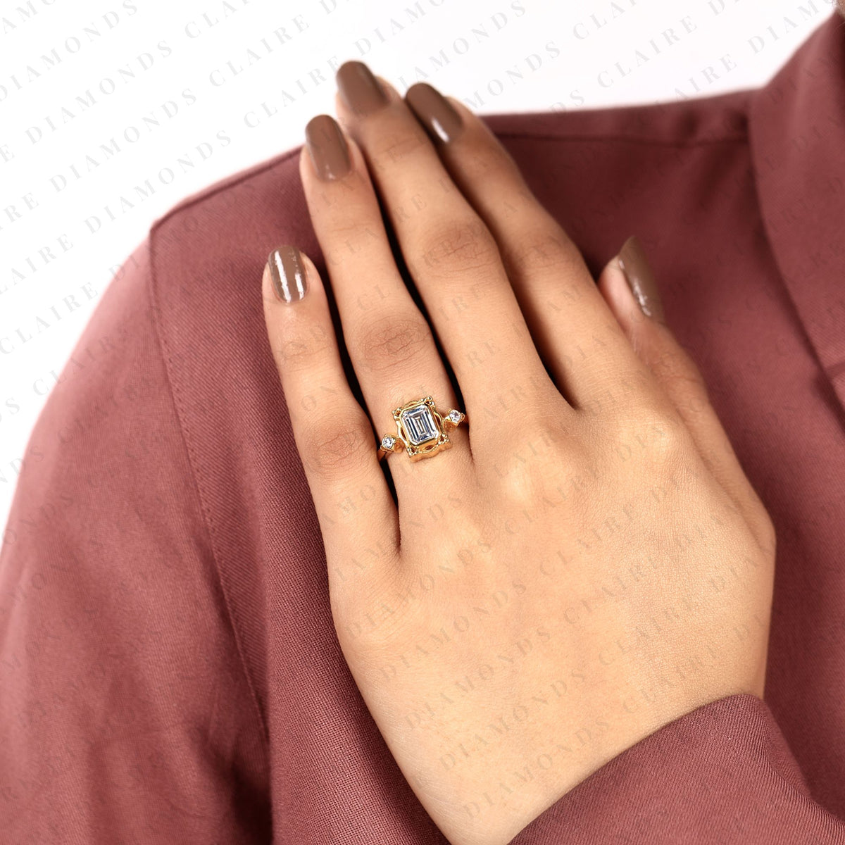 emerald cut three stone bezel set lab grown diamond engagement ring | yellow gold bezel ring with round side diamonds | sculpted luxury bridal ring