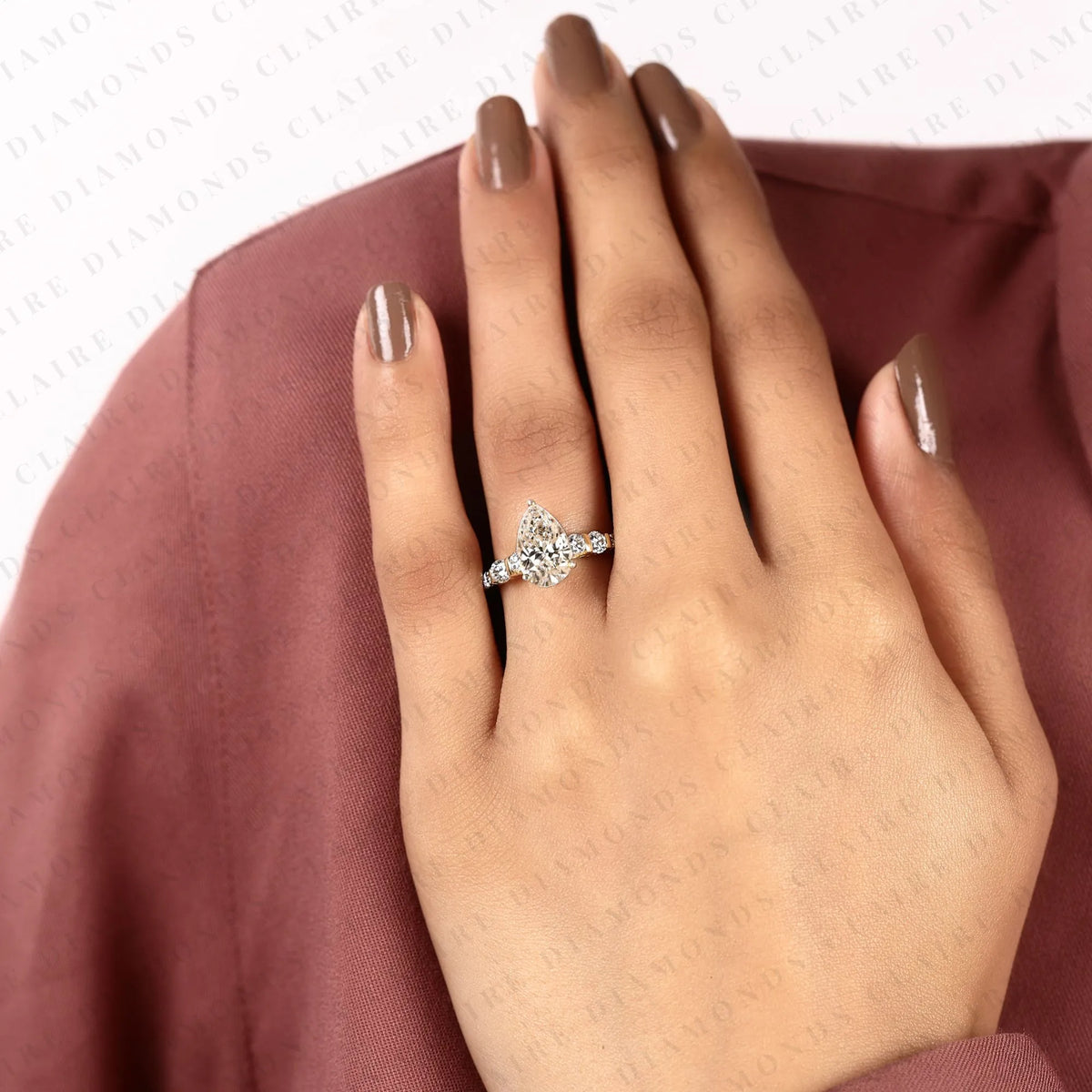 pear cut moissanite diamond engagement ring in two tone gold shoulder ring with round diamond accents