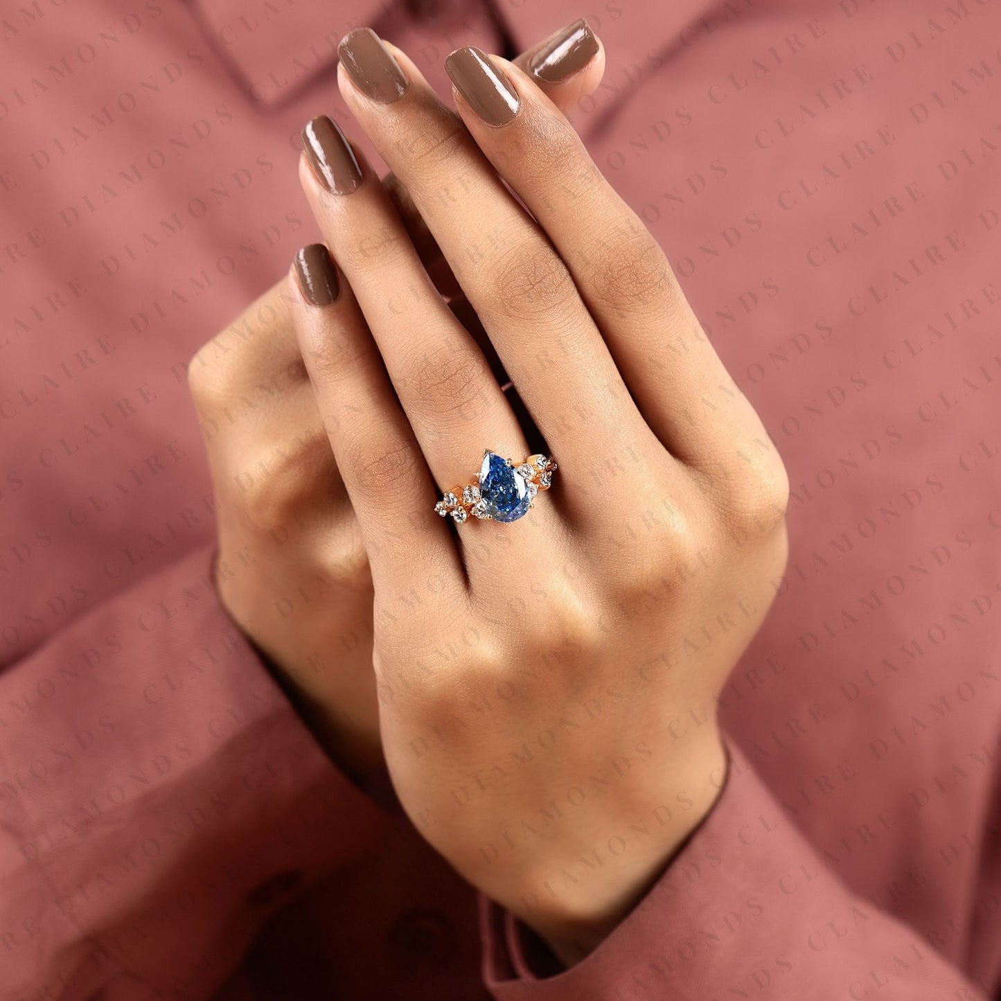 pear cut blue lab grown engagement ring, round diamond floral side stones, yellow gold nature-inspired bridal ring