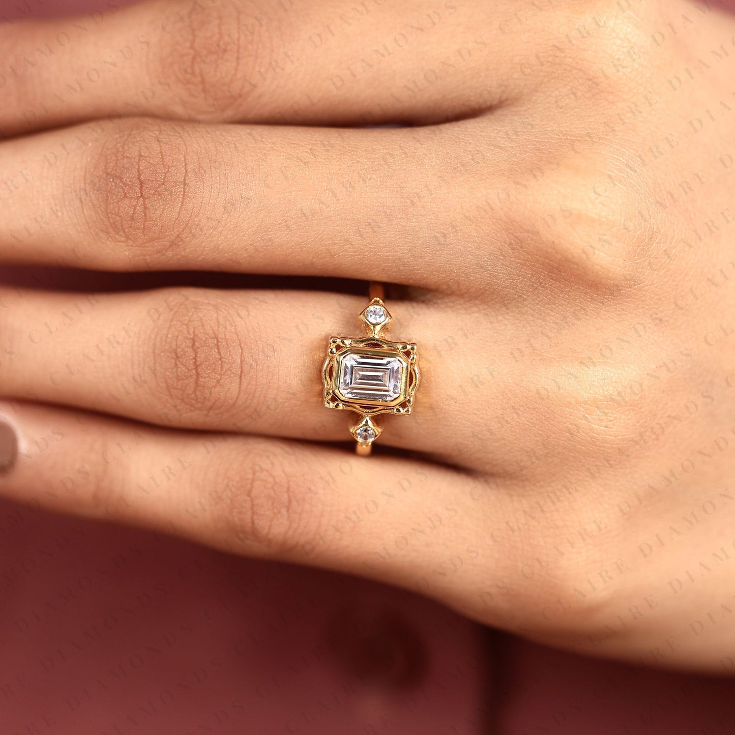 emerald cut three stone bezel set lab grown diamond engagement ring | yellow gold bezel ring with round side diamonds | sculpted luxury bridal ring