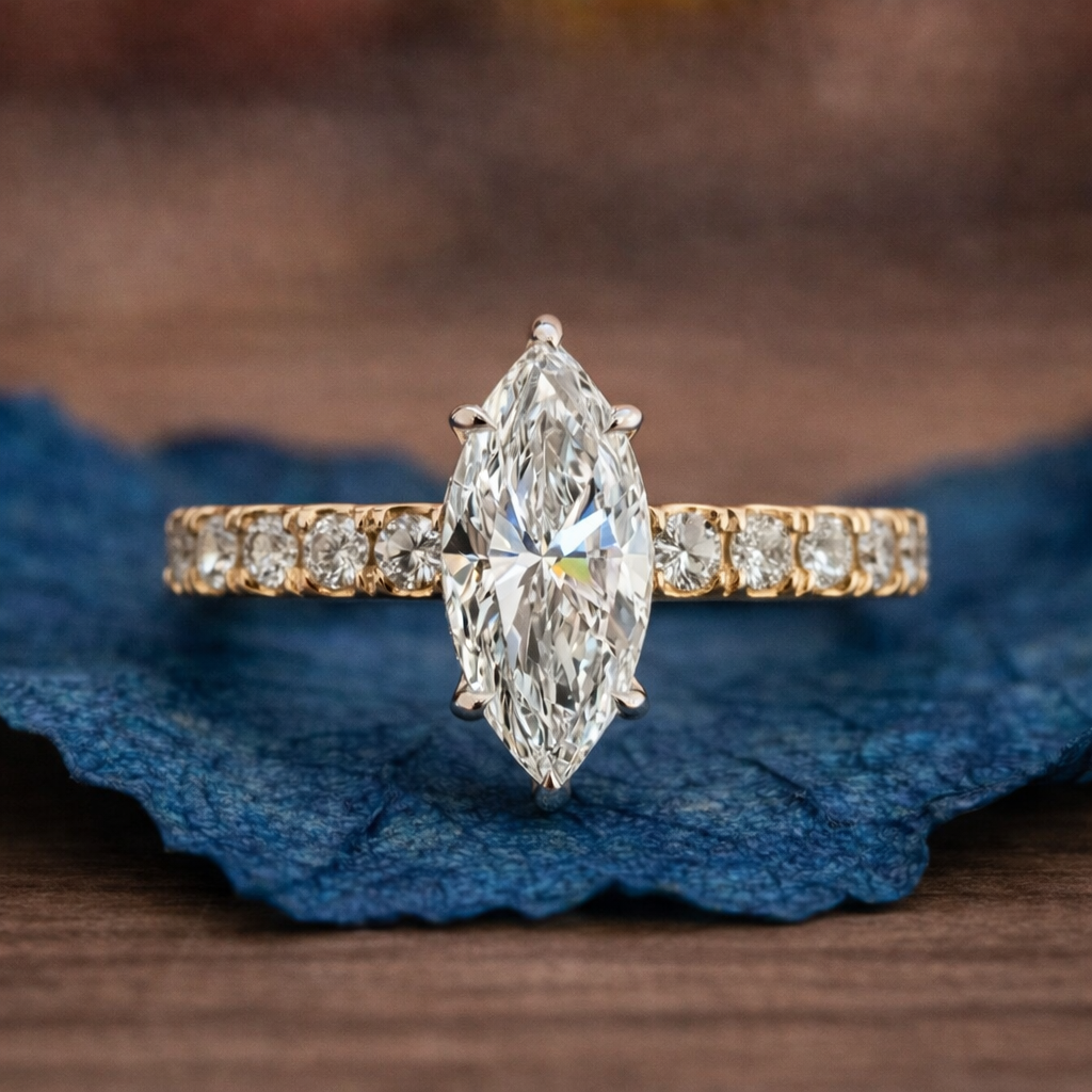 Diamond ring with marquise-shaped center stone on a blue fabric 