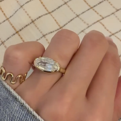 Gold ring with a large diamond on a hand against a checkered