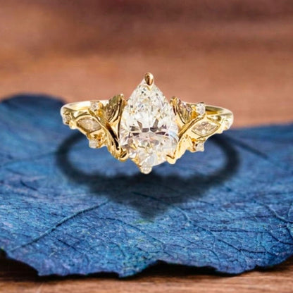 Vintage Inspired Pear Cut Moissanite Diamond Engagement Ring with Floral Leaf Side Accents in Solid Gold