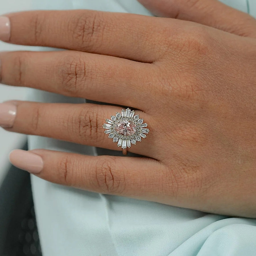 Pink oval ring with ballerina halo in rose gold on a hand