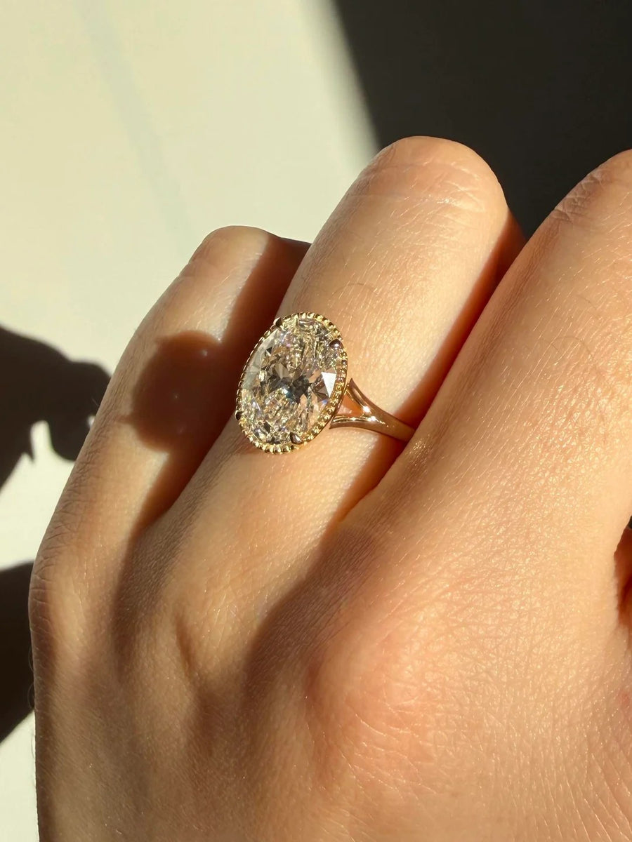 Oval ring with milgrain bezel and split shank in yellow gold