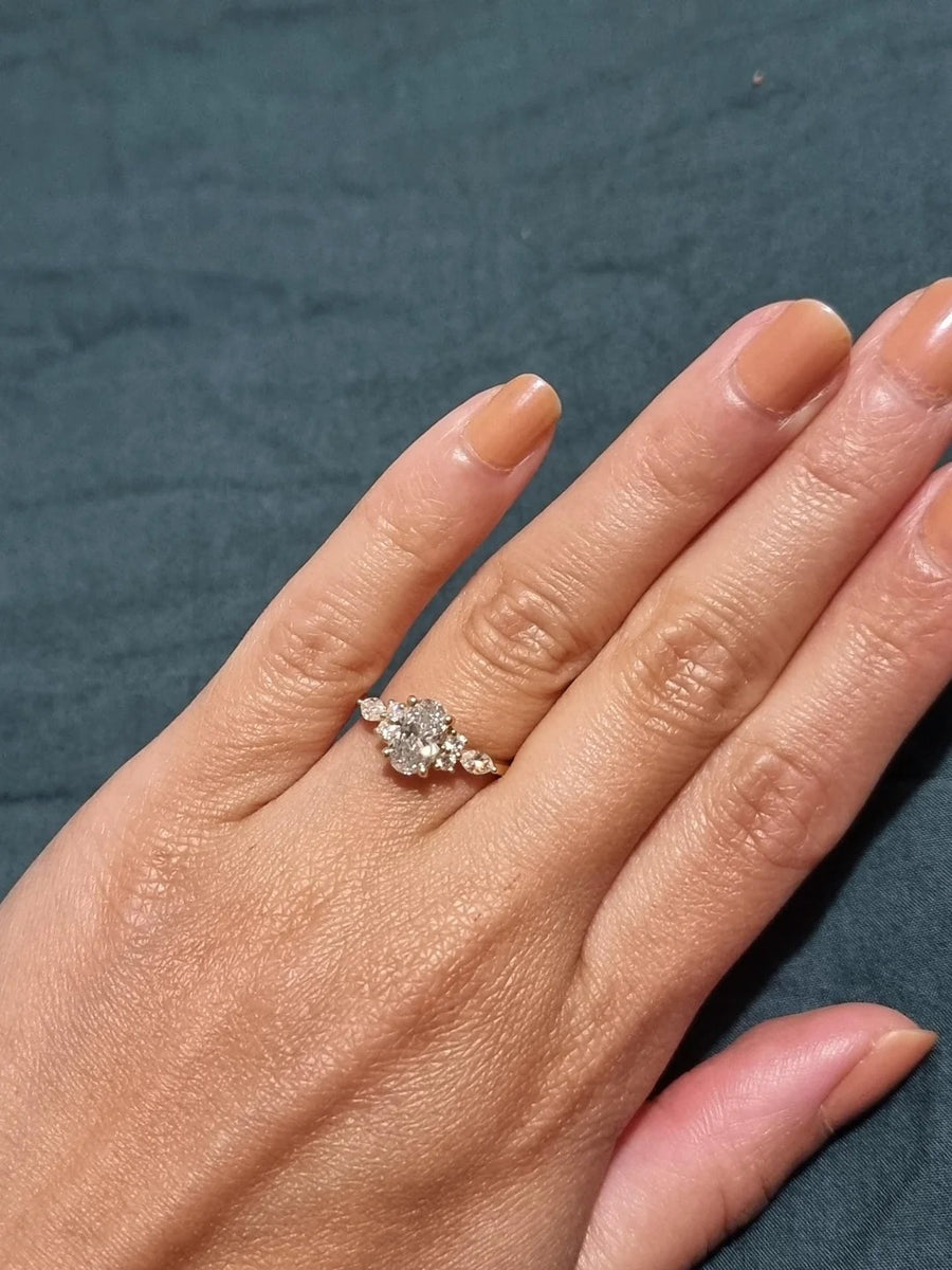 Oval ring with side cluster stones in yellow gold