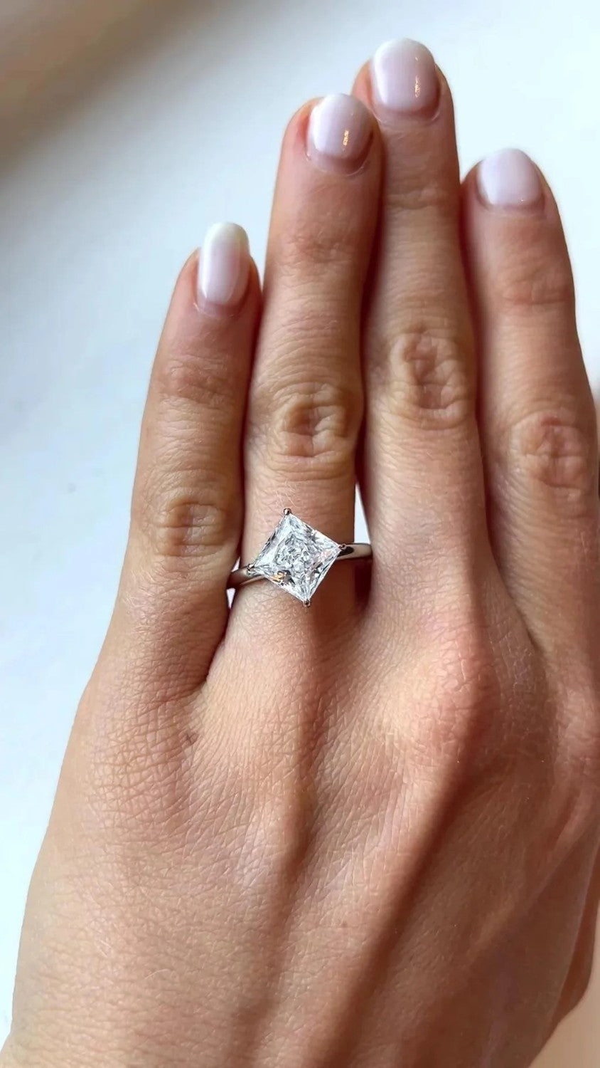 Kite-set princess cut solitaire ring on a hand