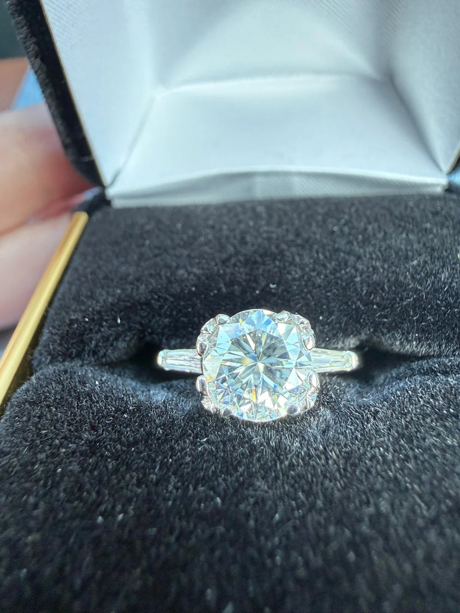 Round ring with baguette side stones in a ring box