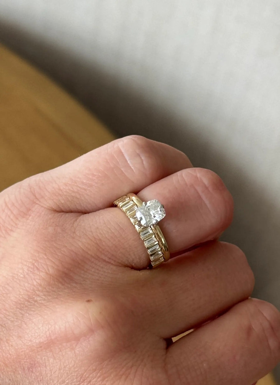Oval solitaire with baguette band in yellow gold