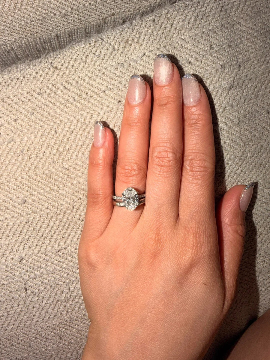Oval solitaire stacked between pave bands