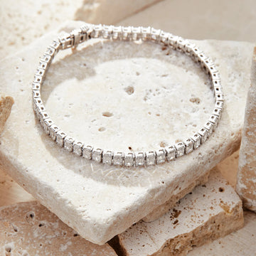 Silver bracelet with clear stones on a textured stone surface