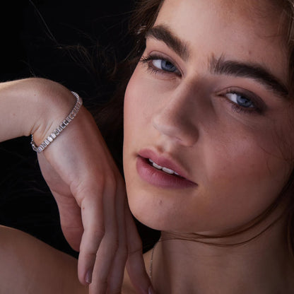Close-up of a woman wearing a diamond bracelet with a dark 