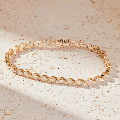 Gold bracelet with clear stones on a beige textured 