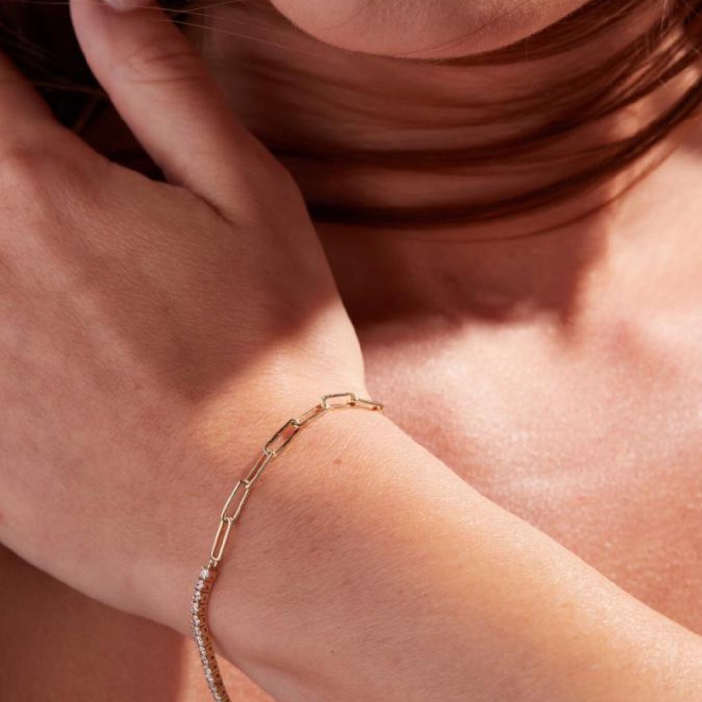 close-up of a person wearing a gold bracelet on a soft 