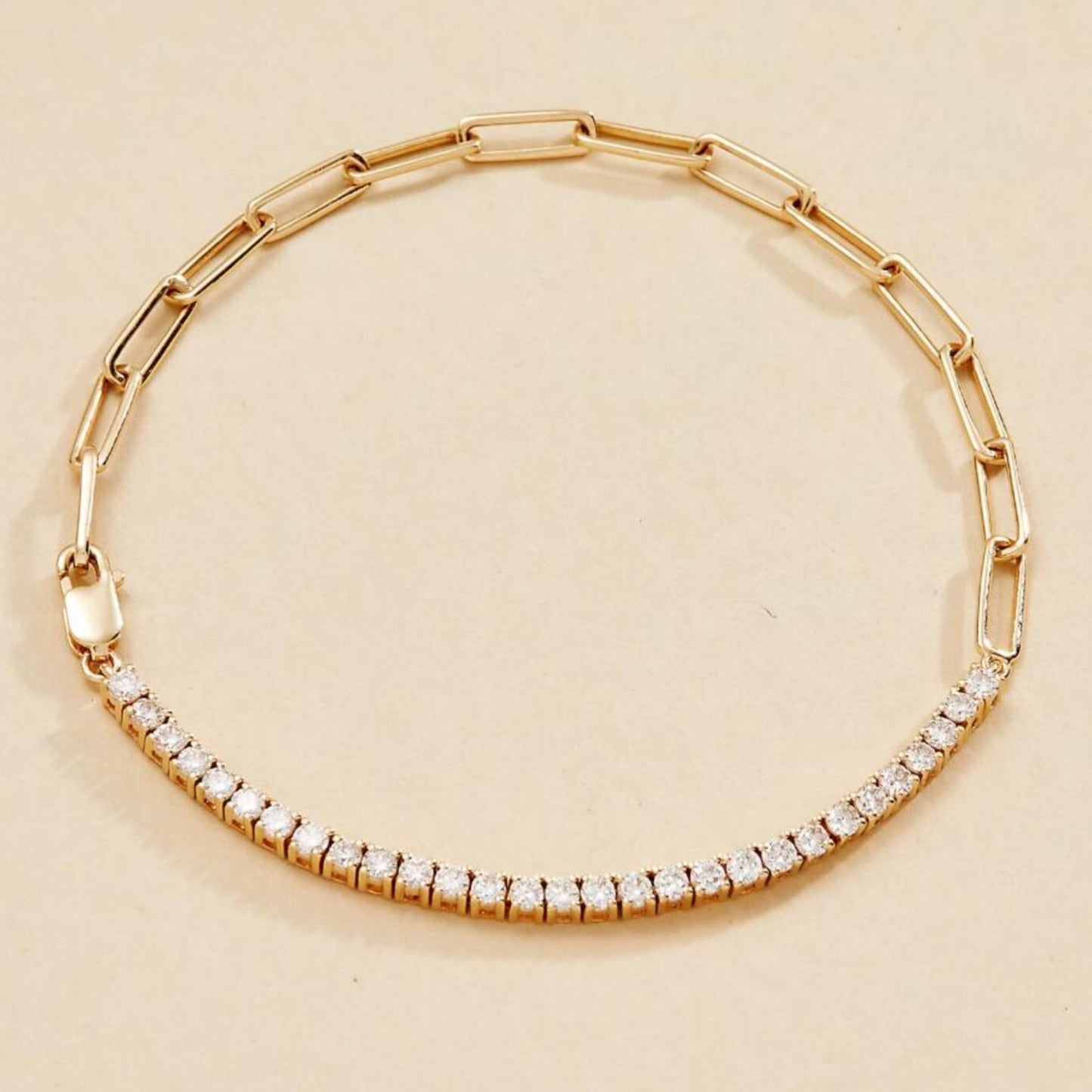 gold bracelet with diamond accents on a beige 