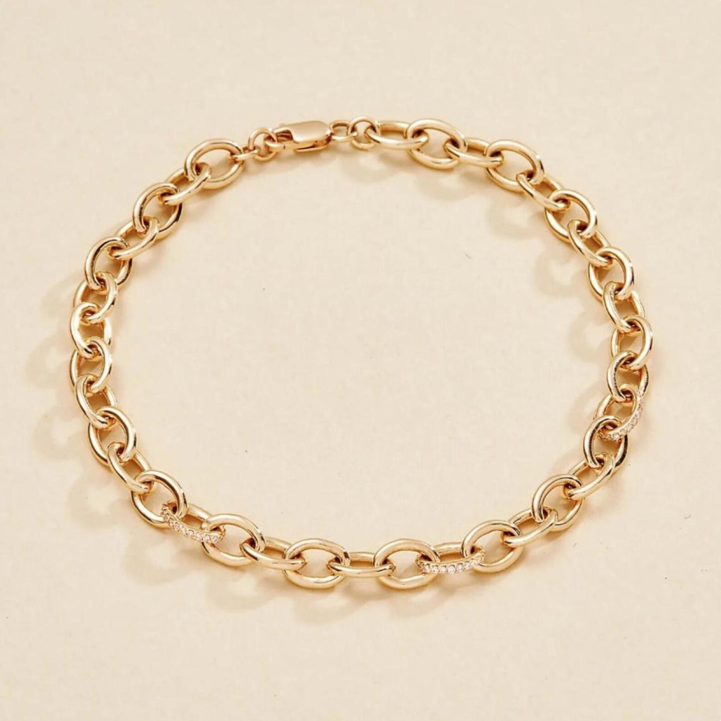 gold chain bracelet on a beige 