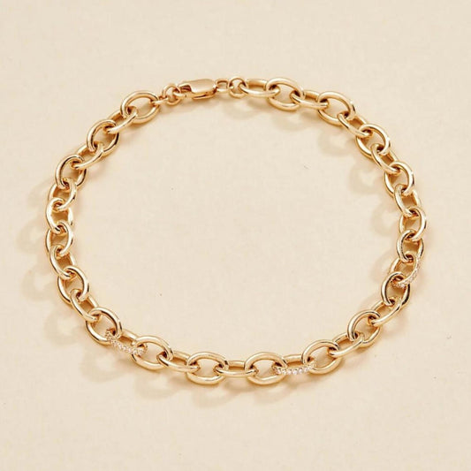 Gold chain bracelet on a beige 